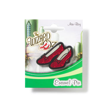 Enamel pin packaging featuring red shoes from 'The Wizard of Oz' on a white background